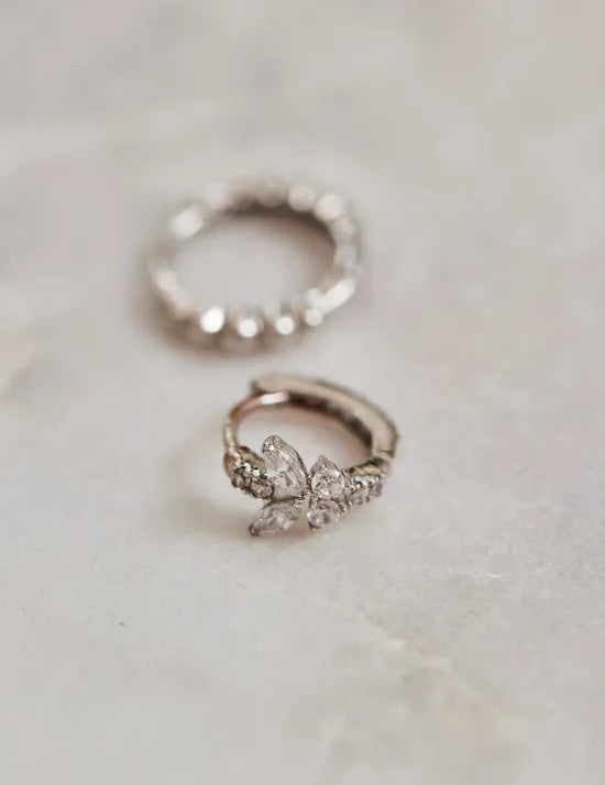 Weißgoldene Creolen liegen auf Mamor