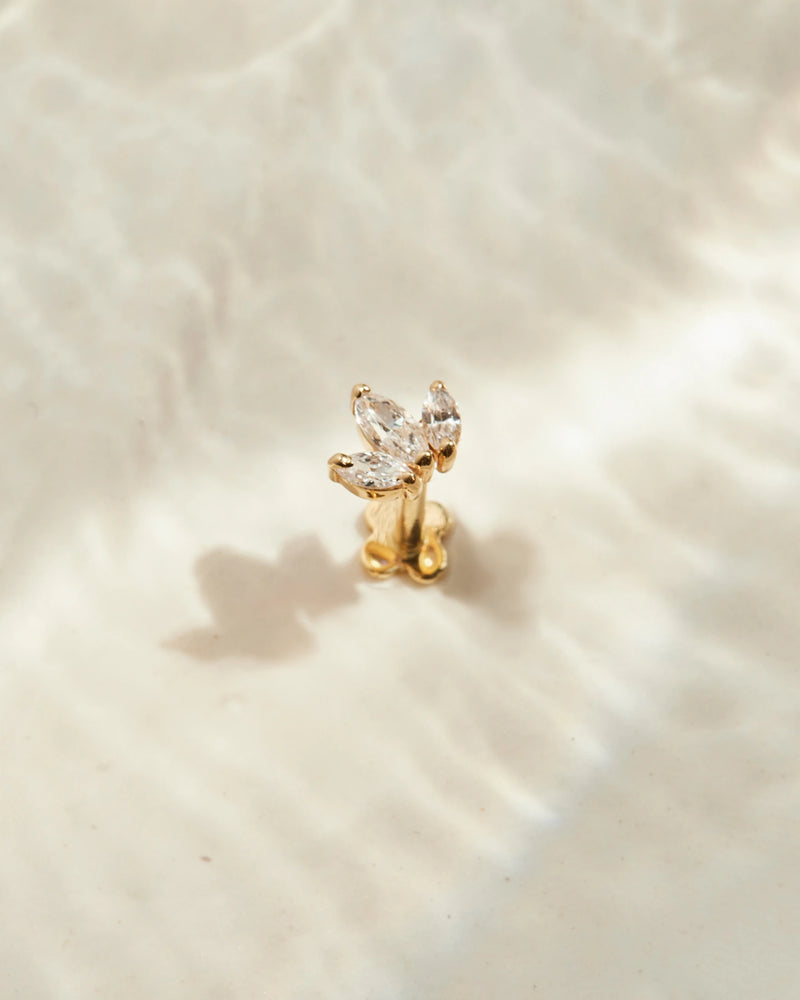 image_Lotus ear stud stands on a beige surface
