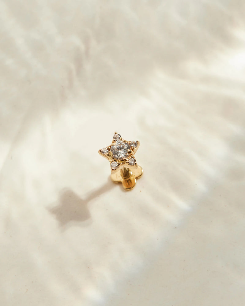 image_Star ear stud stands on a beige surface