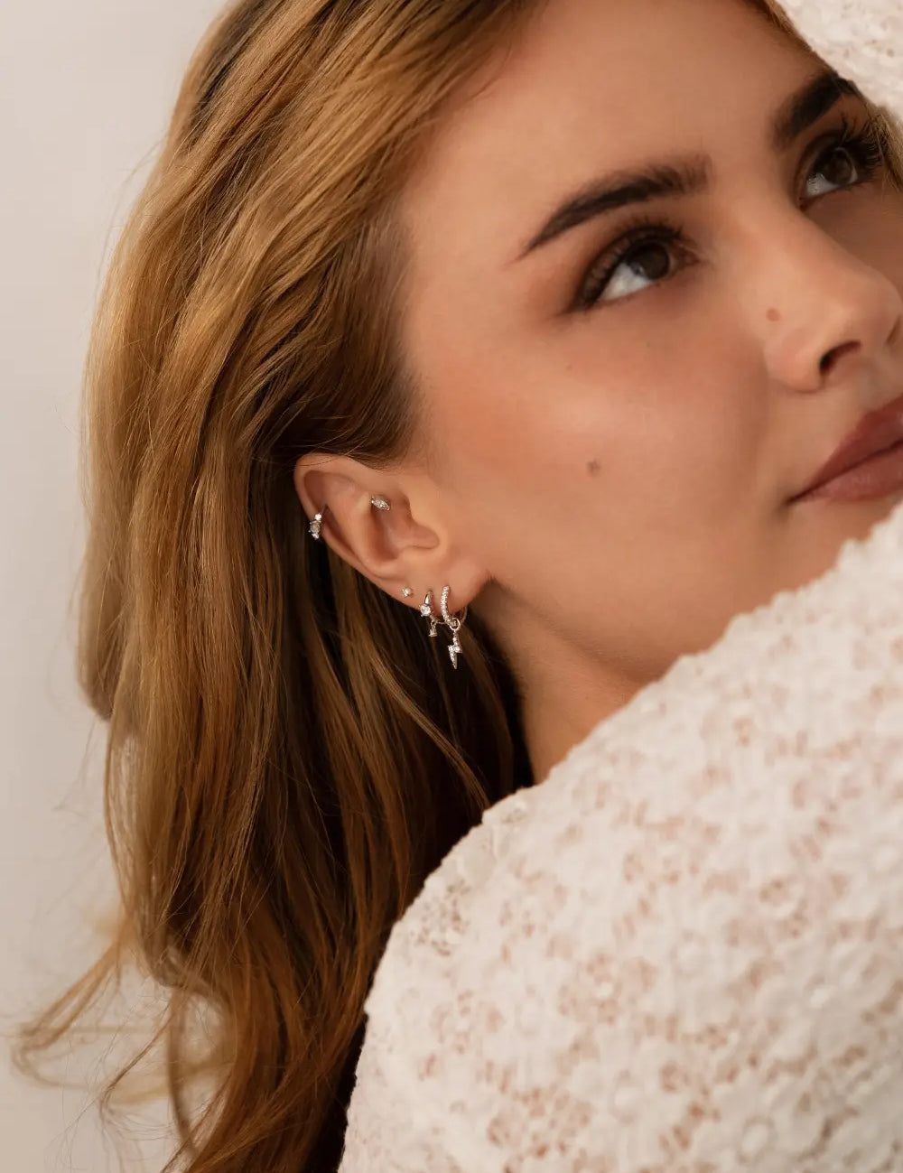 Model with white gold jewelry on her ear