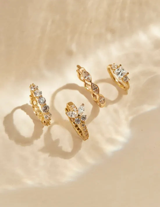 Goldene Creolen stehen auf einer hellen Fläche