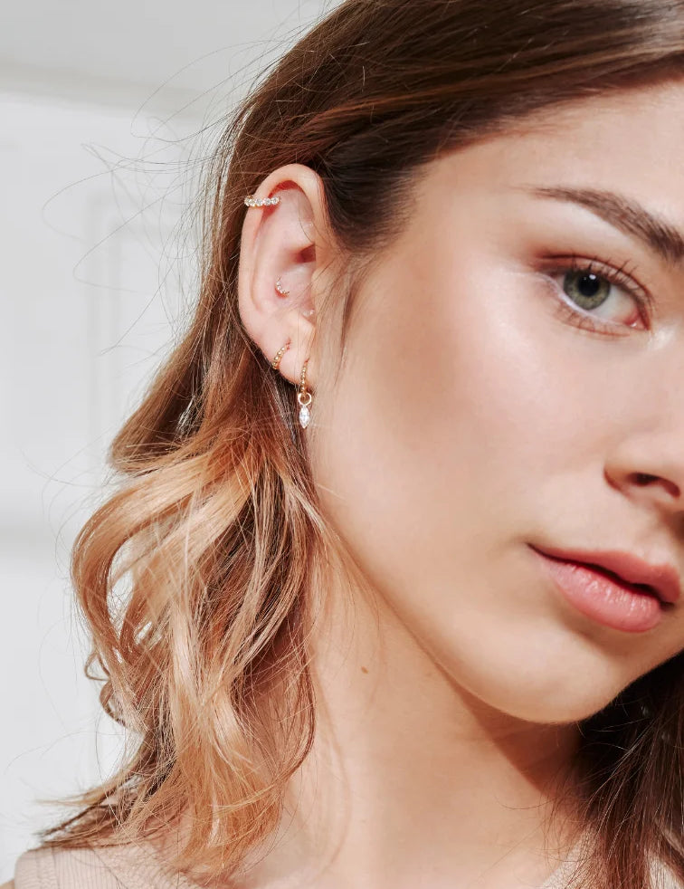 Goldohrringe aus 585 Gelbgold, kombiniert im Alltag getragen am Ohr.