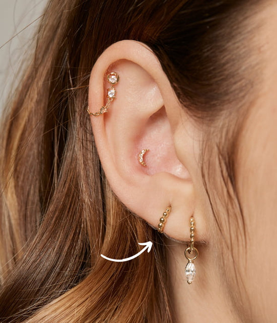 High lobe piercing place symbolized with an arrow