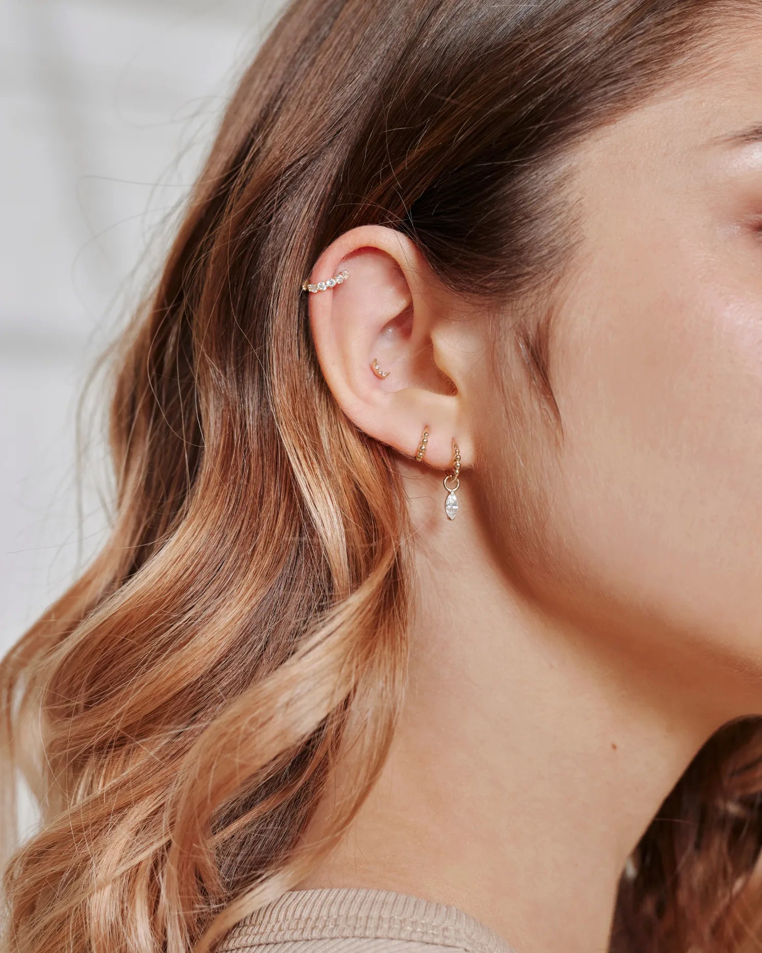 Mehrere Ohrringe für Allergiker am Ohr in Gold