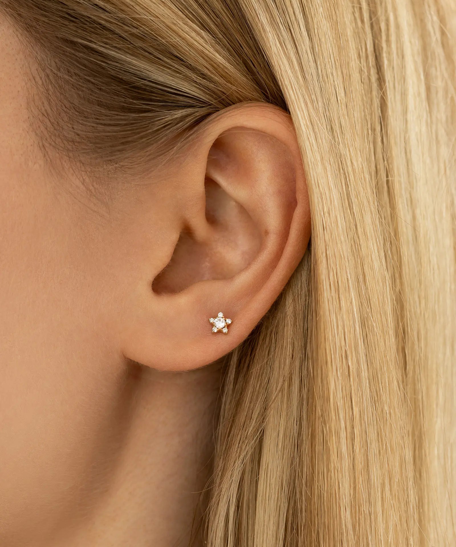Ohrfoto mit dem Stern Piercing Gold am Ohrläppchen