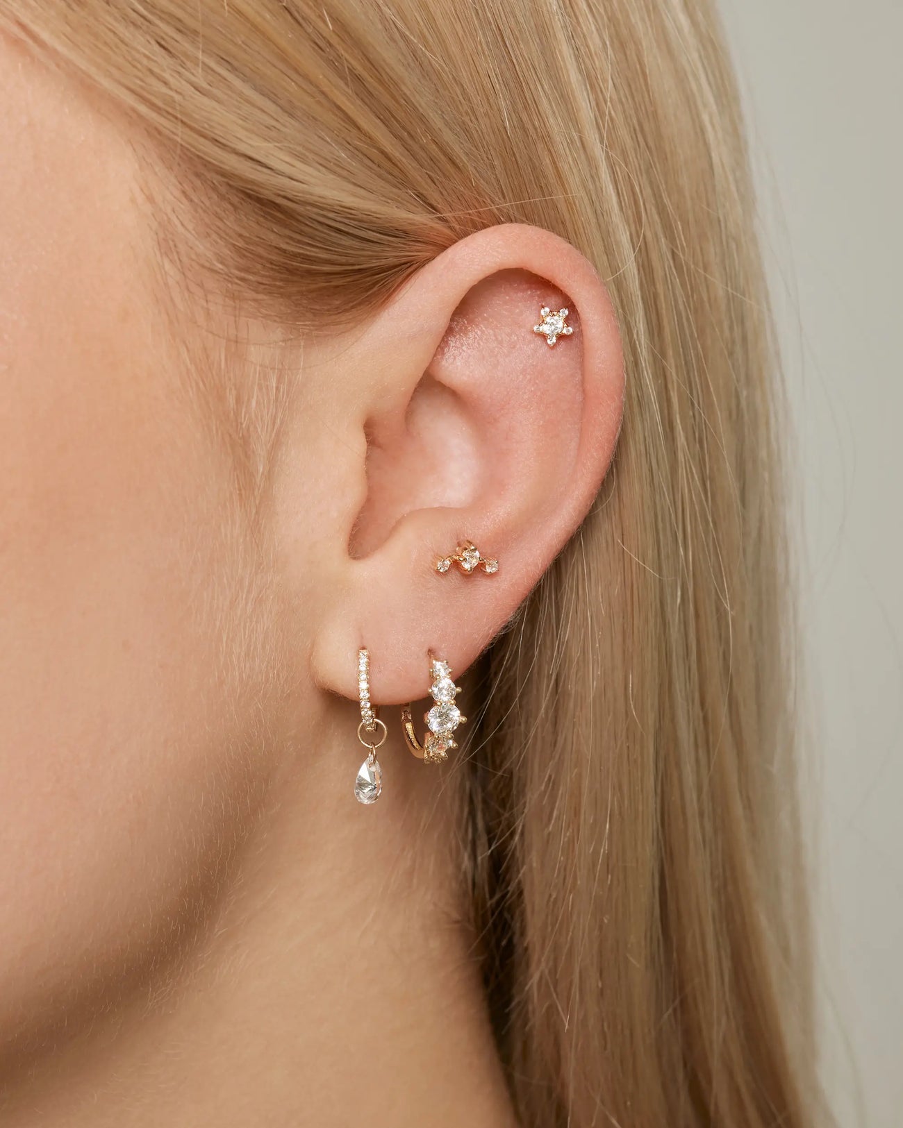 Ohrfoto mit Ohr Piercings und das Stern Piercing in Gold an der Helix Position