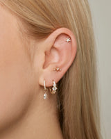 Ohrfoto mit Ohr Piercings und das Stern Piercing in Gold an der Helix Position